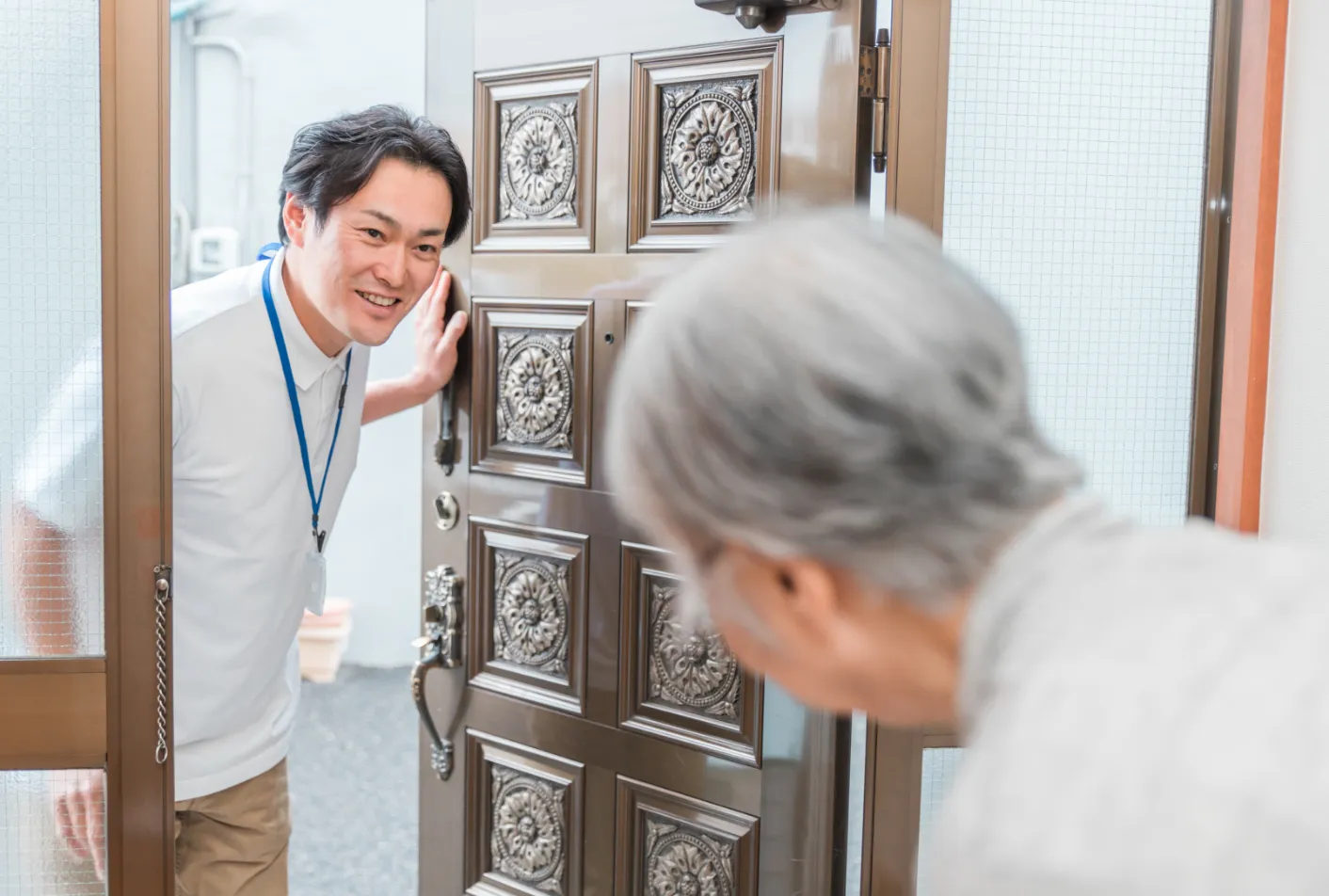 高齢者と笑顔で話す先生