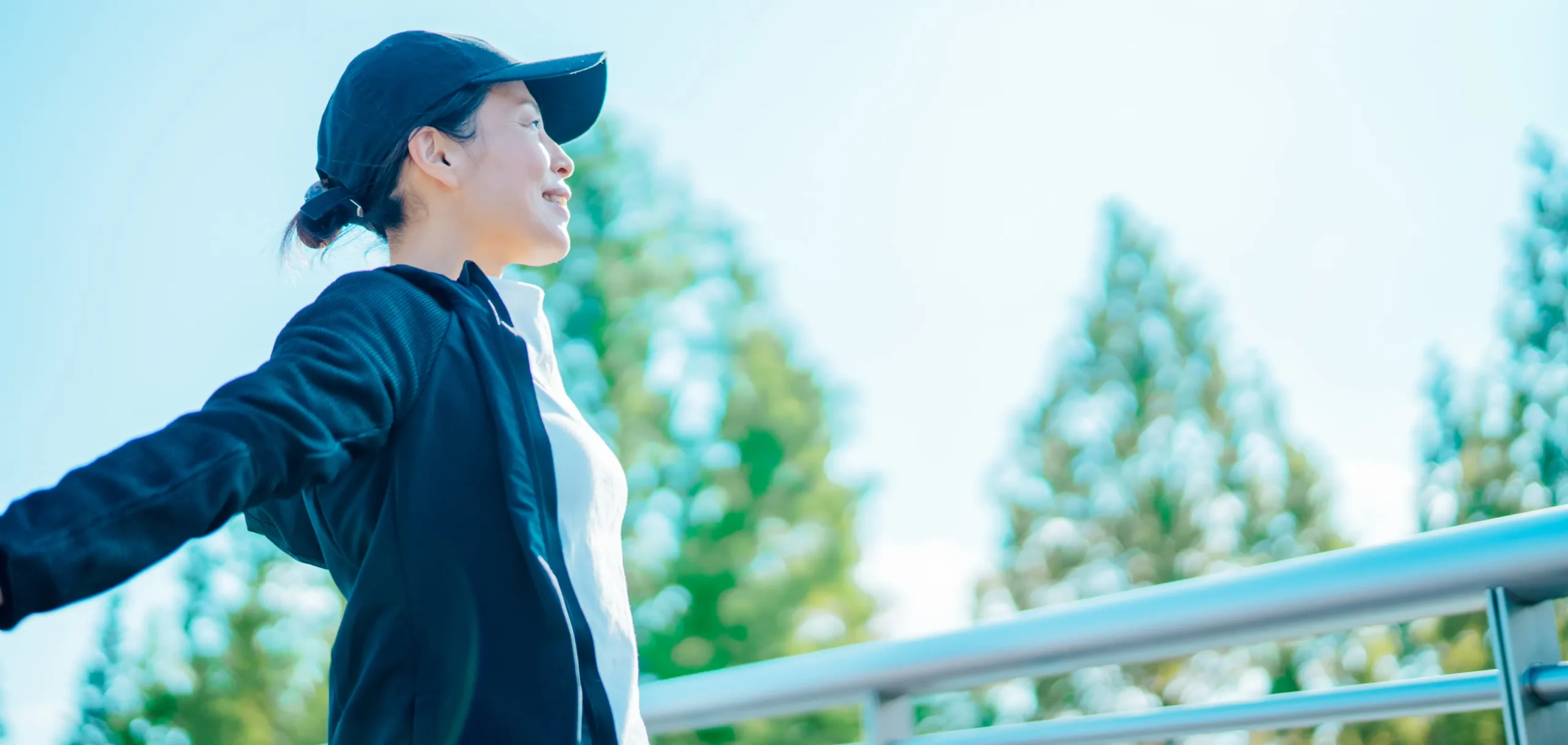 外で手を広げる女性